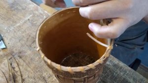 Прошивание края туеса узкой берестяной лентой.
