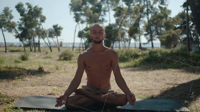 Topless man practicing lotus position with closed eyes on a mat