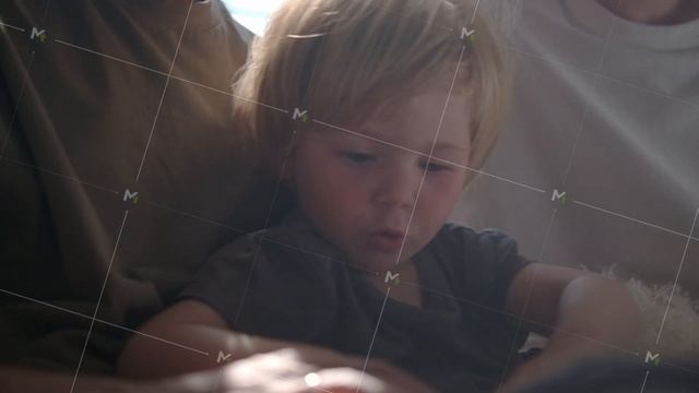 Family with toddler boy read book in a sunny room