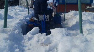 Пробиваю ковшом снег на минитракторе.