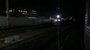 Электропоезд проследовал переезд ночью.