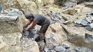 Строительство, шахтёр разбивает камни