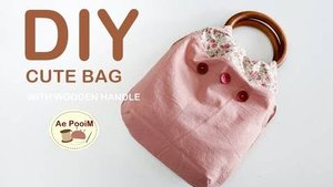 Маленькая сумка с деревянной ручкой.