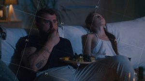 Father watching TV near sleeping daughter