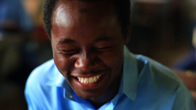 Kenyan teen boy smiles at the camera then laughs. смотреть онлайн