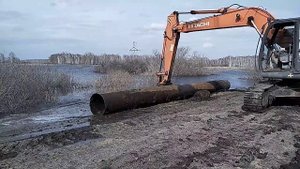 Борьба с наводнением, укладка трубы через дорогу.