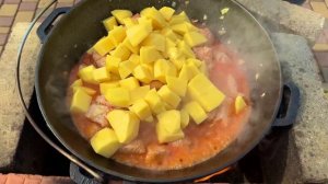 Мясо с овощами в томатном соке в казане на костре