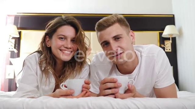 Portrait of Young Couple Lying on Bed and Smiling at Camera. Happy Relationship. Romantic Scene in смотреть онлайн