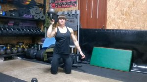 Жим гири дном вверх стоя на коленях