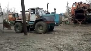 Трактор Т150 вытаскивает груженного зерном Камаза из грязи.