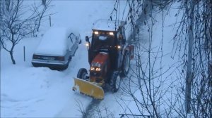 Трактор убирает снег.