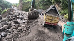 Строительство, экскаватор копает чёрный песок