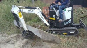 Мини экскаватор укладывает шпалы