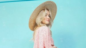 A young fashion model posing on an isolated turquoise background