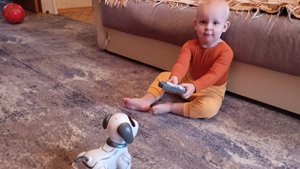 Марк играет с роботом и собакой на пульте управления