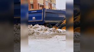 Jcb 3cx super грузит снег в самосвал.
