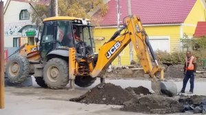 Трактор работает ковшом на дороге