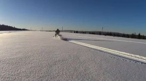По полю.
