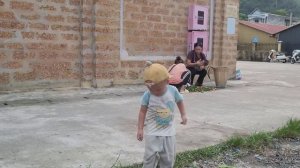 A 17-year-old single mother picks lemons to sell at the market and cleans the grass around the hous