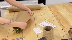 Упаковка букета в крафтовую бумага из 13 малиновых роз.