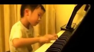 Маленький мальчик играет на пианино