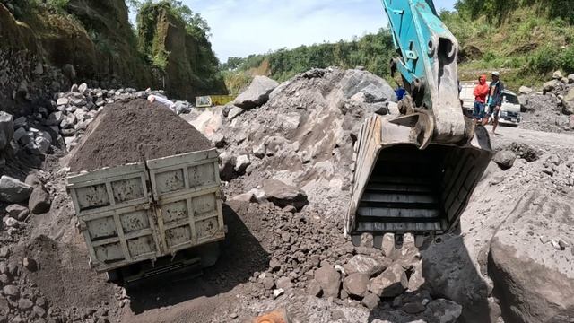 Строительство, экскаватор копает  чёрный песок