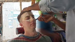 Ловкий барбер умело работает опасной бритвой