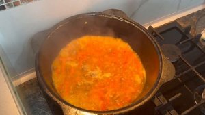 Плов из курице в казане на плите.