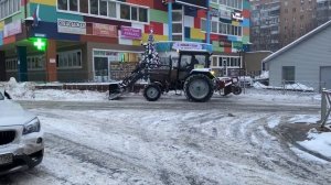 Трактор чистит снег .