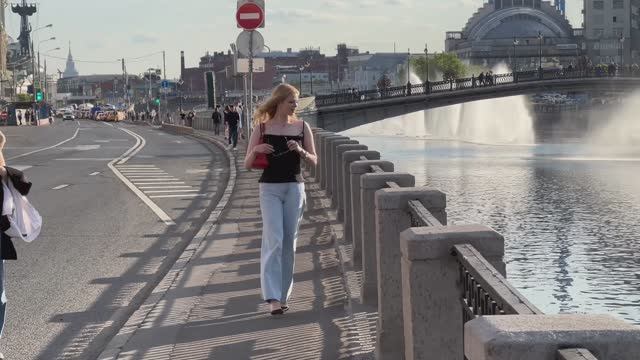 4K.Красивые люди гуляют по набережной реки в Москве.