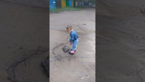 Маруся кидает камушки в лужу