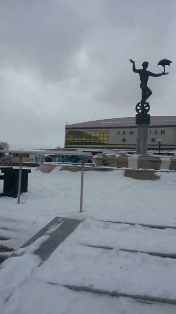 Зима около цирка - мальчик на велосипеде, а вокруг снег и сильный ветер в ноябре 2021 года