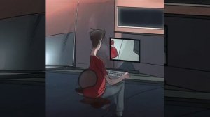 Мужчина в красной рубашке и черных брюках играет на компьютере.