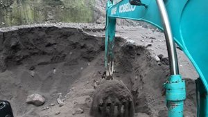 Строительство, экскаватор копает чёрный песок