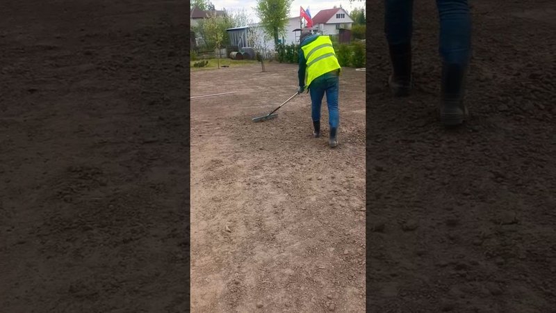 Нивелирование поверхности участка с помощью правила и грабель.