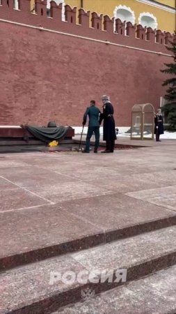 Раненый солдат, опираясь на костыли, встает на одно колено, чтобы почтить память павших у Вечного ог