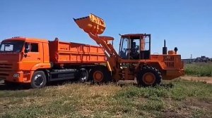 Амкодор 332В грузит Камаз сельхозник
