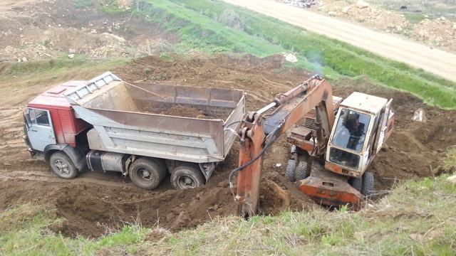 самосвал загружают грунтом экскаватор