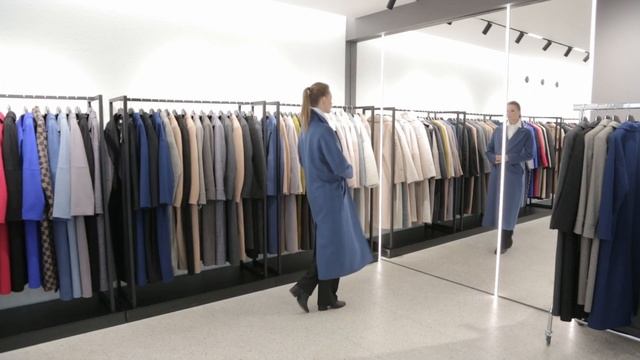 примерка пальто в магазине одежды