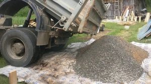 Самосвал высыпает песок и щебень