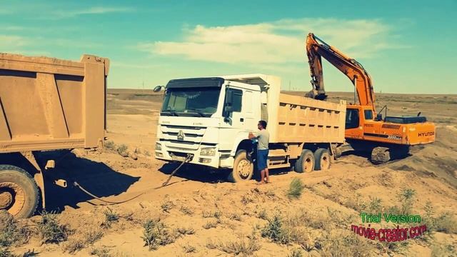 Погрузка песка экскаватором в самосвал на карьере в смотреть онлайн