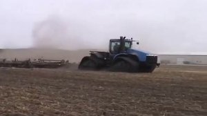 Современный гусенечный трактор пашет землю