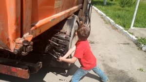 Мальчик 8-ми лет управляет гидравликой мусоровоза.