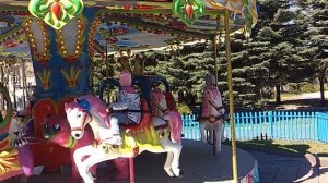 Дети катаются на карусели в Парке развлечений