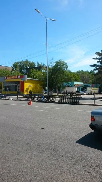 Подбивают части забора из металла и сварщик варит на д