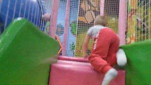 Ребенок прыгает на батуте на детской площадке