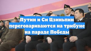 Путин и Си Цзиньпин переговариваются на трибуне на параде Победы