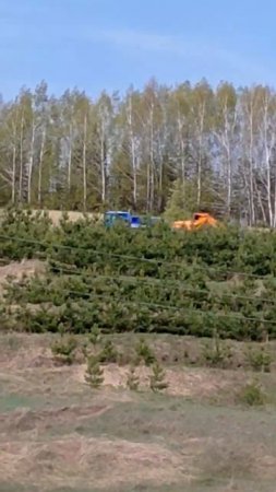 A truck carries an excavator on a trailer
