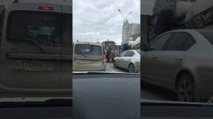 Трактор едет без переднего колеса по улице.