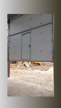 Установка промышленных секционных ворот с калиткой от компании Zaiger